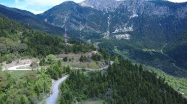 Yunanistan 'dan gelen bu hava görüntüleri, köknar ağaçları arasına telekomünikasyon antenleri yerleştirilmiş dağlık bir bölgeyi gösteriyor. Akdeniz Ormanı 'ndan çok sayıda vilayet yolu geçiyor..