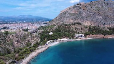 Yunanistan 'dan gelen bu insansız hava aracı görüntüleri Akdeniz' in kayalık bir körfezinde yüzmek için ideal olduğunu gösteriyor. Dağlar denizin üzerinde yükselir ve ağaçlar kıyı şeridinin yanında yetişir. Nafplio uzaktan görülebilir..