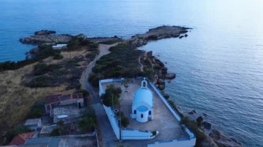 Bu İHA görüntülerinde Yunanistan 'daki kayalık bir Ege adasında bulunan geleneksel bir Rum Ortodoks kilisesi görülüyor. Yapı mavi bir çatı, haç ve çan kulesi içerir ve günbatımından hemen önce çekilir..
