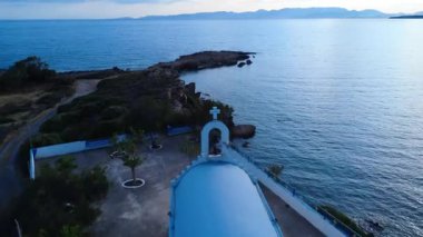 Yunanistan 'dan gelen bu İHA görüntüleri, kayalık bir Ege adasındaki geleneksel bir Rum Ortodoks kilisesini gösteriyor. Mavi çatılı şapel güneş batmadan hemen önce kıyıya vuran dalgalar tarafından ele geçirildi..