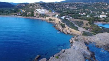 Yunanistan 'dan gelen bu insansız hava aracı günbatımında kayalık bir Ege kıyı şeridini gösteriyor ve kamera yavaşça kıyıdan uzaklaşıyor. Dalgalar yavaşça hareket eder ve uzakta bir sahil belirir..