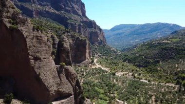 Yunanistan 'daki kayalık uçurumlardan geçen bir İHA, zeytin koruluğu ve eyalet yolundan geçen bir Akdeniz vadisini ortaya çıkardı.