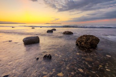 Kayalık bir sahilde gün batımı manzarası. Alor Adası, Doğu Nusa Tenggara - Endonezya
