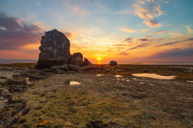 Sahildeki kayaların gün batımında çekildiği bir manzara. Görkemli günbatımı gökyüzü. Feifanja Sahili, Alor, Doğu Nusa Tenggara, Endonezya