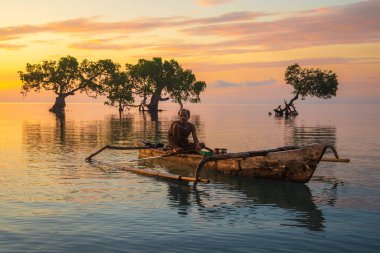 Alacakaranlıkta teknesiyle balık tutan yaşlı bir adam. Alor, Doğu Nusa Tenggara - Endonezya - 4 Nisan 2018