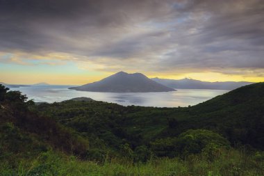 Bulutlu bir günde, yeşil bir tepeden okyanus manzarası. Bampalola, Alor, Doğu Nusa Tenggara - Endonezya
