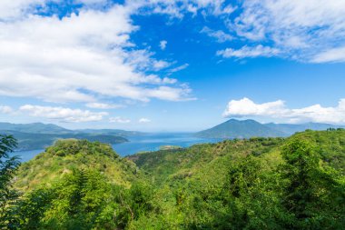 Güneşli bir günde yeşil bir tepeden mavi deniz manzarası. Bampalola, Alor, Doğu Nusa Tenggara - Endonezya.