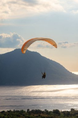 Öğleden sonra havada bir paraglider uçar. Alor, Doğu Nusa Tenggara - Endonezya (17 Haziran 2023)