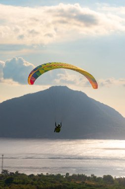 Öğleden sonra havada bir paraglider uçar. Alor, Doğu Nusa Tenggara - Endonezya (17 Haziran 2023)