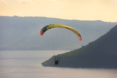 Öğleden sonra havada bir paraglider uçar. Alor, Doğu Nusa Tenggara - Endonezya (17 Haziran 2023)