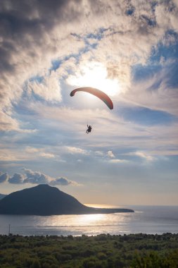 Öğleden sonra havada bir paraglider uçar. Alor, Doğu Nusa Tenggara - Endonezya (17 Haziran 2023)