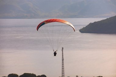 Öğleden sonra havada bir paraglider uçar. Alor, Doğu Nusa Tenggara - Endonezya (17 Haziran 2023)