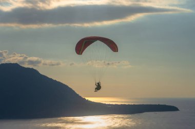 Öğleden sonra havada bir paraglider uçar. Alor, Doğu Nusa Tenggara - Endonezya (17 Haziran 2023)