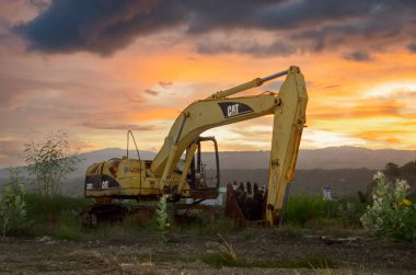 Terk edilmiş kırık bir tırtıl kazıcısının alacakaranlık görüntüsü. Alor Adası, Doğu Nusa Tenggara, Endonezya - 23 Ocak 2016