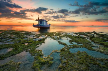 Gün batımında batımında batan bir teknenin görüntüsü. Kelapa Lima Plajı, Kupang Şehri, Doğu Nusa Tenggara - Endonezya