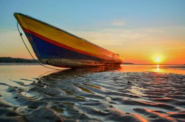 Gün batımında batan bir denizde bir tekne manzarası. Oesapa Plajı, Kupang şehri, Doğu Nusa Tenggara - Endonezya