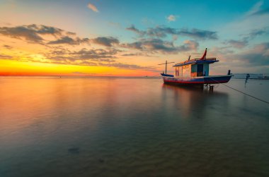 Gün batımında batımında batan bir teknenin görüntüsü. Kelapa Lima Plajı, Kupang Şehri, Doğu Nusa Tenggara - Endonezya