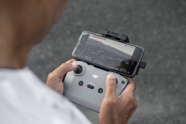 DJI Mavic Air 2 insansız hava aracının uzaktan kumandası cep telefonuna bağlı. Alor - Endonezya, 28 Nisan 2025