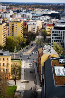 Wroclaw Polonya 'nın panoramik görüntüsü gözcü kulesinden alındı. Fotoğrafta Oder Nehri boyunca tarihi binalar ve köprüler de dahil olmak üzere canlı şehir manzaraları sergileniyor. Açık bir gökyüzü ve güneşli bir gün şehirleri vurguluyor.