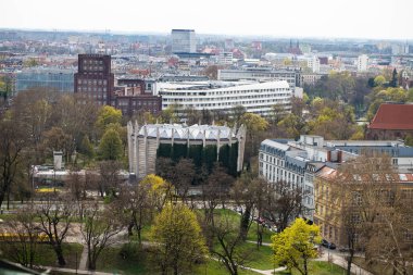 Wroclaw Polonya 'nın panoramik görüntüsü gözcü kulesinden alındı. Fotoğrafta Oder Nehri boyunca tarihi binalar ve köprüler de dahil olmak üzere canlı şehir manzaraları sergileniyor. Açık bir gökyüzü ve güneşli bir gün şehirleri vurguluyor.