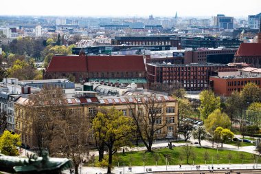 Wroclaw Polonya 'nın gözcü kulesinden alınan çarpıcı panoramik görüntüsü. Renkli çatıları, tarihi mimarisi ve parlak, berrak gökyüzünün altındaki dolambaçlı Oder Nehri ile şehrin cazibesini yakalıyor. Canlı bir şehir manzarası için mükemmel.