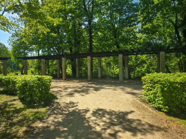 Çevresi yeşilliklerle çevrili manzaralı bir parkta kıvrımlı yürüyüş yolları. Boş zaman, şehir doğası, açık hava aktiviteleri veya çevre dostu şehir tasarımı kavramları için idealdir..