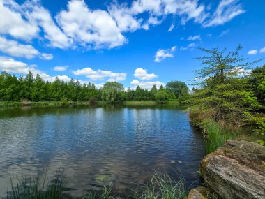 Parlak mavi gökyüzünün altında nefes kesici bir göl manzarası. Kristal berrak su, yemyeşil kıyılar ve mükemmel yansımalar. Seyahat, reklam, web siteleri ve duvar kağıtları için ideal. Yüksek kalite, doğal güzellik.