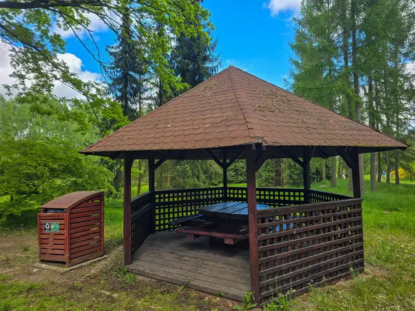 Ağaçlar ve çiçeklerle çevrili güzel bir park çardağı. Manzara tasarımı, turizm ve kentsel gelişim projeleri için mükemmel. Uyumlu atmosferi olan rahat dinlenme yeri.