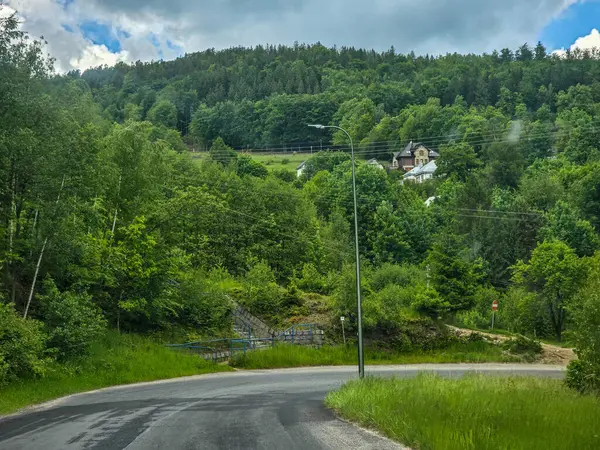 Yüksek tepelerden geçen dolambaçlı bir yolu olan çarpıcı bir dağ manzarası. Seyahat reklamları, ilham verici projeler ve macera markaları için mükemmel.