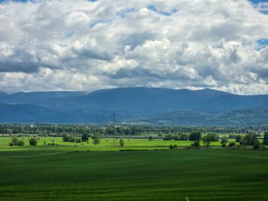 Uçsuz bucaksız zirveleri olan büyüleyici dağ manzarası bulutlarda kayboluyor. Seyahat markaları, ilham verici projeler ve eko-tasarım için mükemmel.