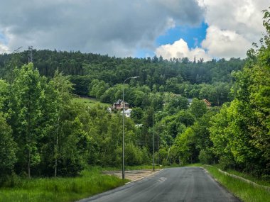 Yüksek tepelerden geçen dolambaçlı bir yolu olan çarpıcı bir dağ manzarası. Seyahat reklamları, ilham verici projeler ve macera markaları için mükemmel.