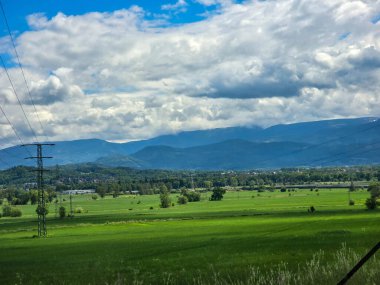 Uçsuz bucaksız zirveleri olan büyüleyici dağ manzarası bulutlarda kayboluyor. Seyahat markaları, ilham verici projeler ve eko-tasarım için mükemmel.