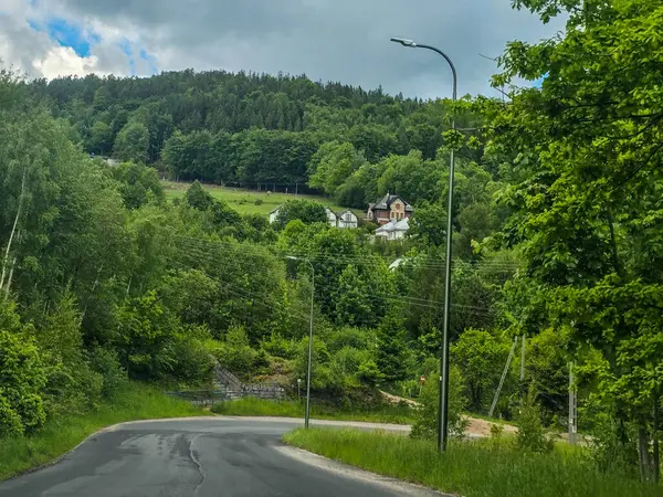 Yüksek tepelerden geçen dolambaçlı bir yolu olan çarpıcı bir dağ manzarası. Seyahat reklamları, ilham verici projeler ve macera markaları için mükemmel.