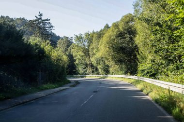 Bu büyüleyici stok fotoğrafı, ufka doğru uzanan, macerayı, özgürlüğü ve yeni başlangıçları sembolize eden çarpıcı, dolambaçlı bir yola işaret ediyor. Pürüzsüz asfalt nefes kesici manzarayı keser, kusursuz doğal ışıkla yıkanır.