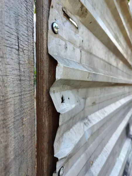 Metal bir inşaat kapısının ayrıntıları, paslanma ve yıpranma belirtileri gösteriyor..