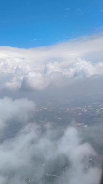 Bulutları, mavi gökyüzünü ve Endonezya 'nın Java adasını gösteren bir uçak penceresinin HD video görüntüsü..