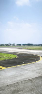 Uzağa uzanan bir havaalanı pistinin fotoğrafı, uçak kalkış ve inişlerde kullanılır, seyahat, havacılık, ulaşım ve lojistik temalar için mükemmeldir..