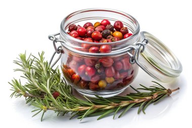 Canlı kurumuş gül kalçalarıyla dolu cam bir kap taze kekik ve biberiye dallarının yanında oturur, zengin dokular ve kırsal botanik düzende topraksı aromalar harmanlanır..