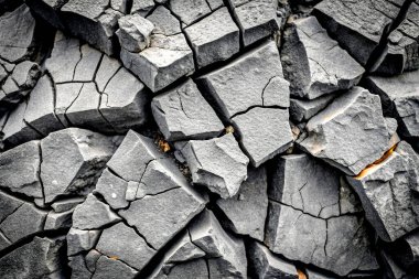 Close-Up of Cracked Black Volcanic Lava Stone Texture with Toned Effect