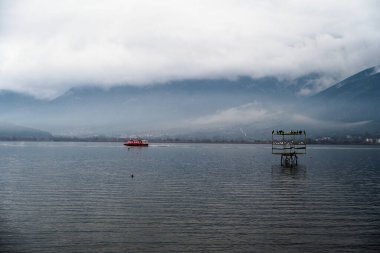 Ioannina 'da Pamvotis Gölü' nden geçen kırmızı bir tekne var.