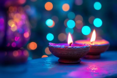 Özellikler, sıcak bir parıltı saçan bir masanın üzerine toprak lambaları (Diyas) yaktı. Renkli bokeh ışıkları arka planı dolduruyor, yumuşak odaklı şenlikli bir atmosfer yaratıyor.