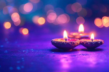 Alevli geleneksel kil divalar. Bulanık, bokeh dolu bir arkaplanı olan koyu mor desenli bir yüzeye yerleştirilmiş, canlı bir atmosfer yaratıyor..