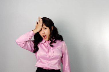 Pembe tişört giyen, el hareketi yapan, kafasını okşayan Asyalı bir kadın. Reklam kavramı