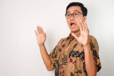 Batik takan, gözlüklü, şaşırtıcı ve komik ifadeler takınan Asyalı adam.