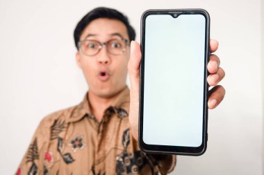 Akıllı telefonlara odaklanmış ve yüzü bulanık gözlüklü Asyalı bir adam tarafından tutulan boş beyaz ekranlı akıllı telefon.