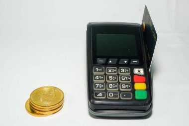 EDC makinesine eklenen kredi kartı ve beyaz arkaplanda bulunan bitcoin