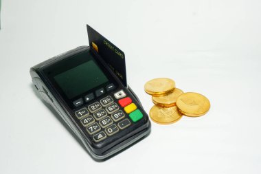 EDC makinesine eklenen kredi kartı ve kenara saçılmış bitcoin, kredi kartı kullanarak bitcoin satın alma kavramı