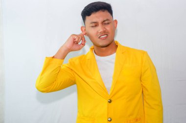 Sarı takım elbiseli genç Asyalı adam kulak ağrısı