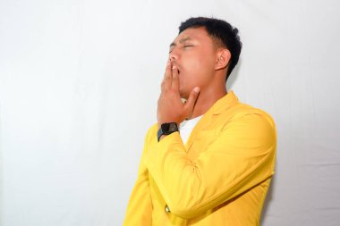 Heyecanlı genç Asyalı adam esneme hareketi yapıyor