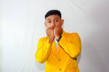 Sarı takım elbiseli heyecanlı Asyalı genç adam.